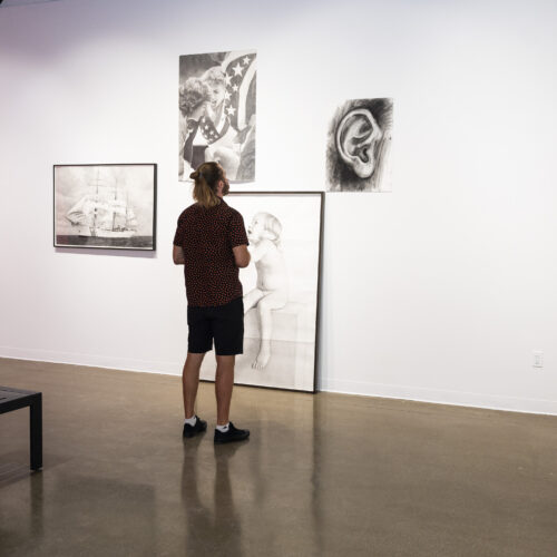 A person views artwork on display at Kimball Art Center