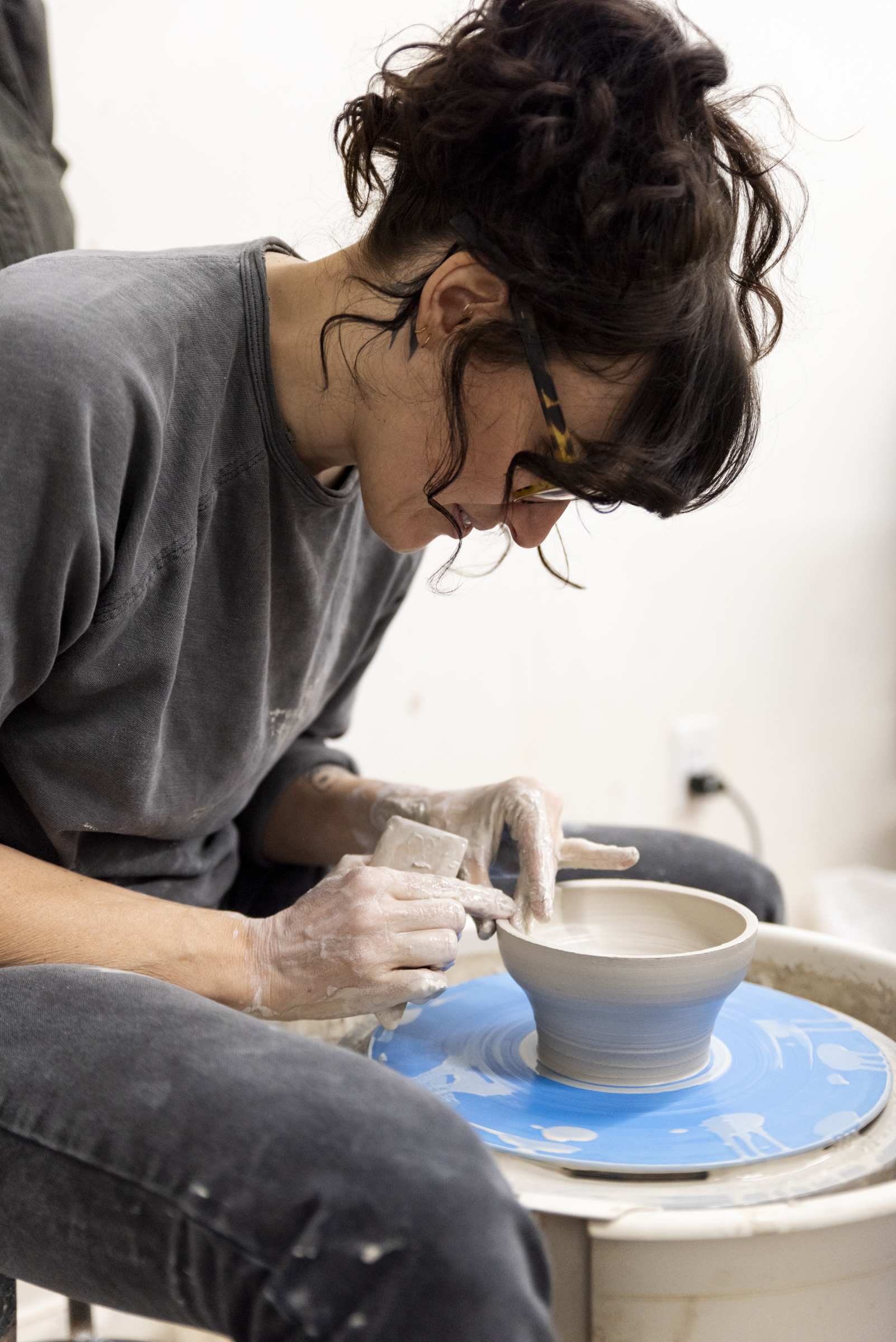 a person uses a pottery wheel to create ceramic art at a Kimball Art Center art workshop