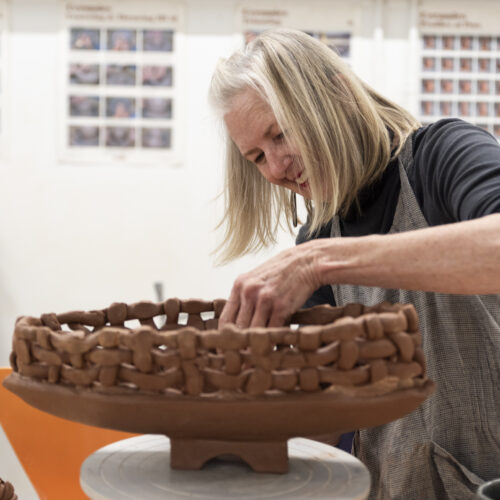 A person participates in an adult handbuilding art class at Kimball Art Center
