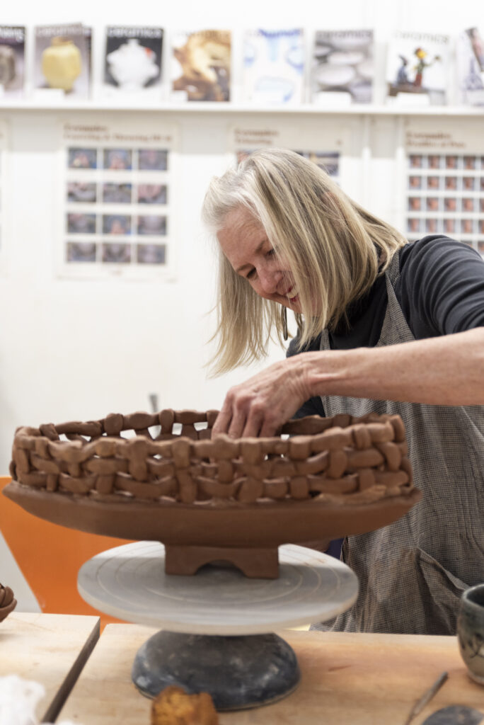 A person participates in an adult handbuilding art class at Kimball Art Center